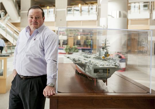 Timothy "Rhino" Paige, a 26-year Air Force veteran living with PTSD, stands near a model of the USS George H.W. Bush at Patuxent River (Md.) Naval Air Station.(Photo: William Jay Westcott, for USA TODAY)